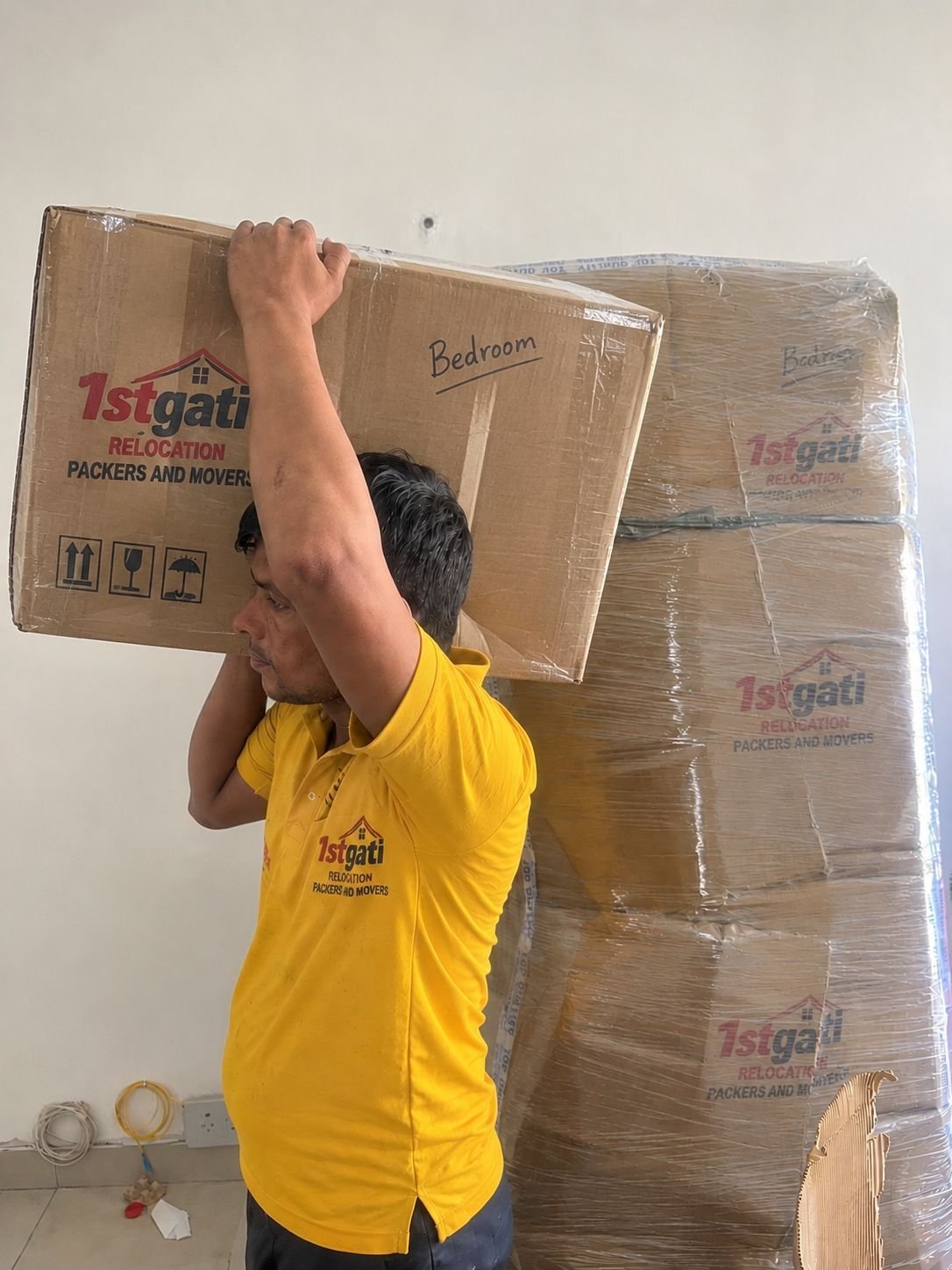 Worker carrying labeled bedroom box with care